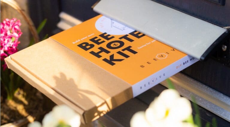 A bee hotel DIY kit being posted through a door