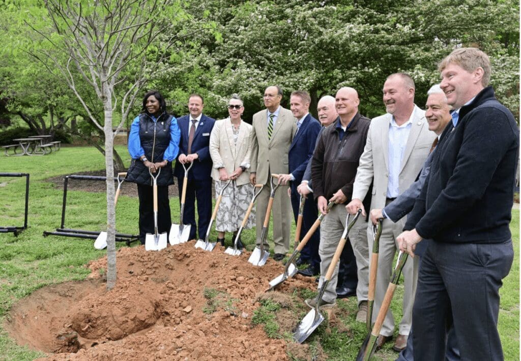 Members of The LEGO Group gather with shovels around a newly planted tree for photo opportunity.