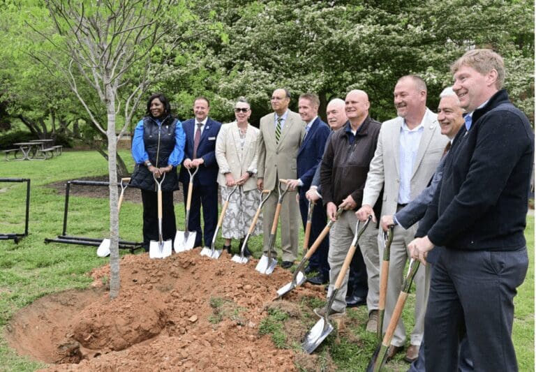 Members of The LEGO Group gather with shovels around a newly planted tree for photo opportunity.