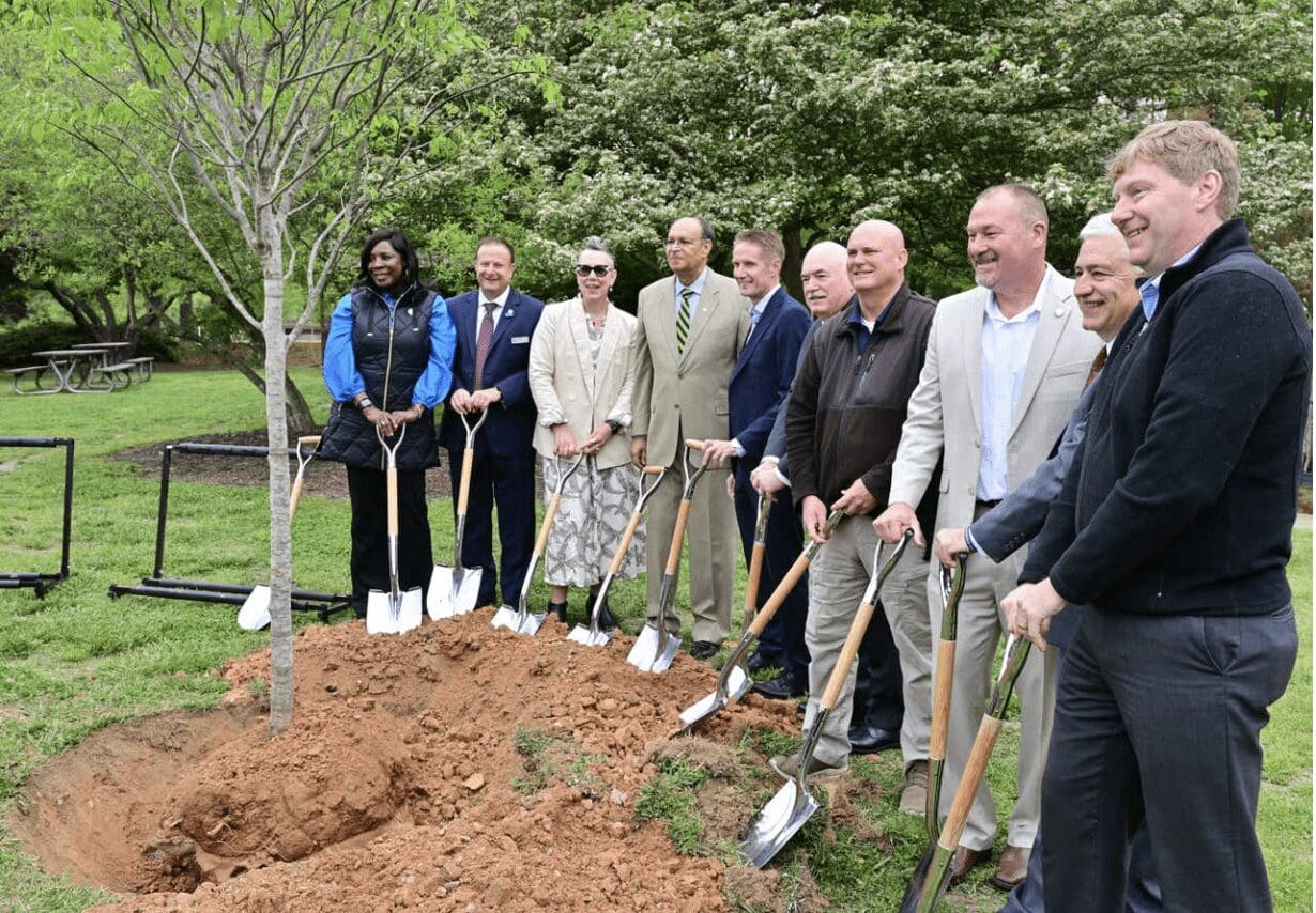 Members of The LEGO Group gather with shovels around a newly planted tree for photo opportunity.