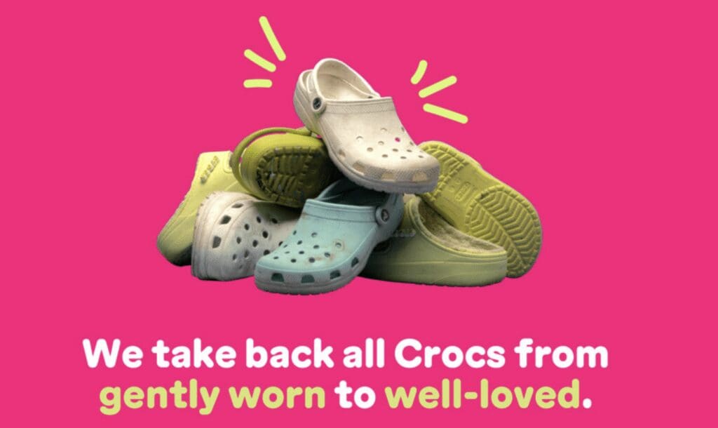 A bundle of crocs shoes arranged on a bright fuscia background.
