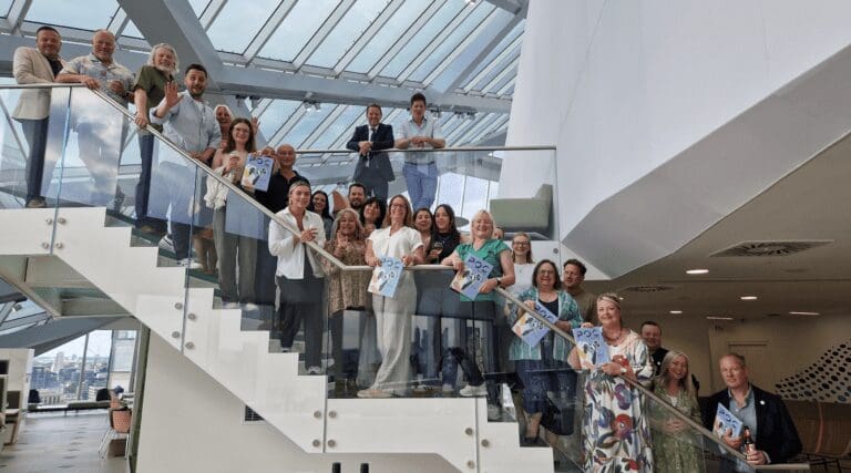 Products of Change members line up on the stairs at the Informa offices in London