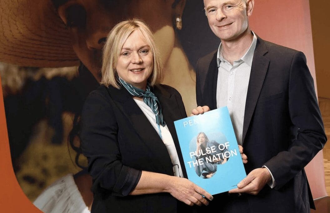 Lynne Walker and Ossian Smyth stand holding a copy of the 2024 Pulse of the Nation Index by Penneys