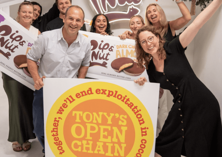 Pip & Nut's team of men and women stand behind a Tony's Chocolonely logo as they cheer