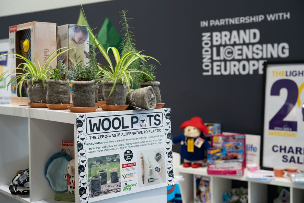Houseplants and herbs in small knitted wool pots on a shelf on the POC booth.