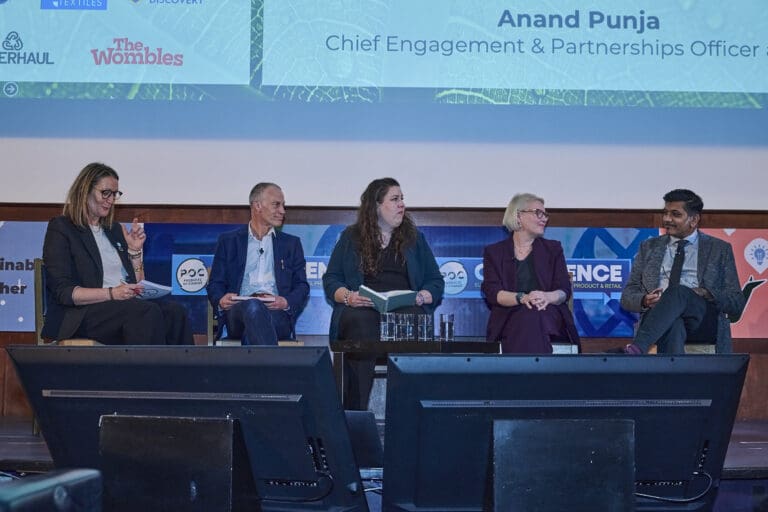 Five people are seated on a conference stage.