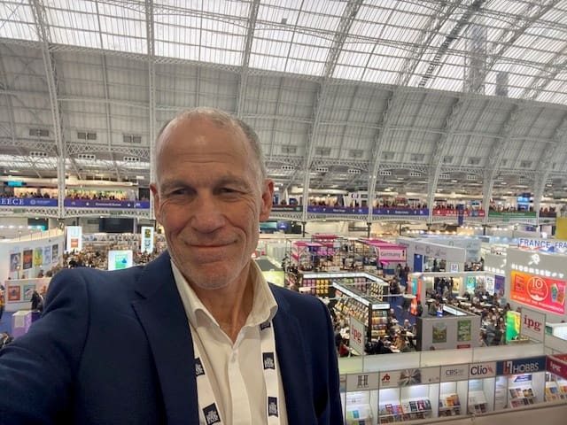 Steve poses from a balcony view of a trade show floor below