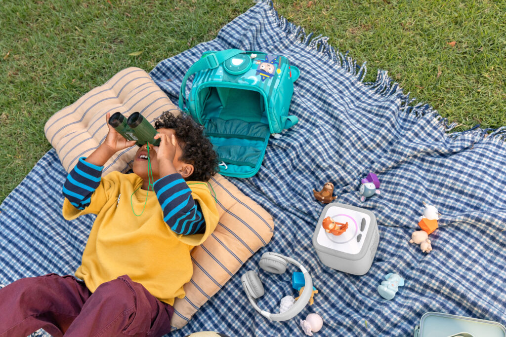 Lifestyle image of child on picnic rug with a Toniebox