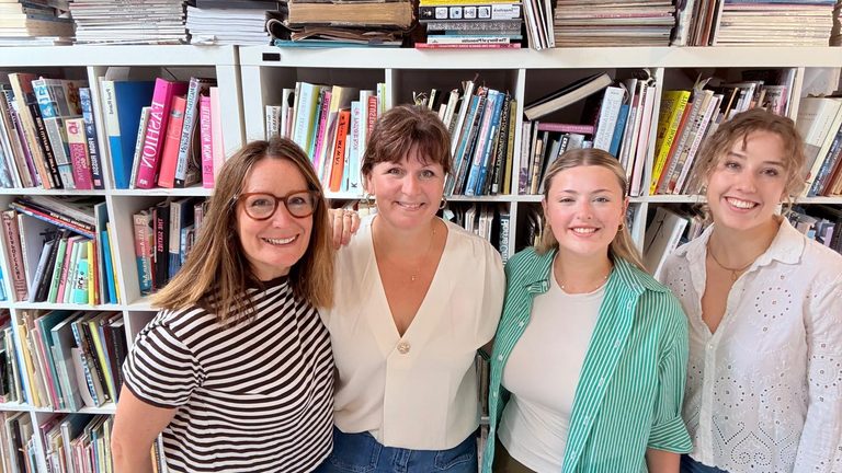 Team POC smiling for the camera in front of bookshelves