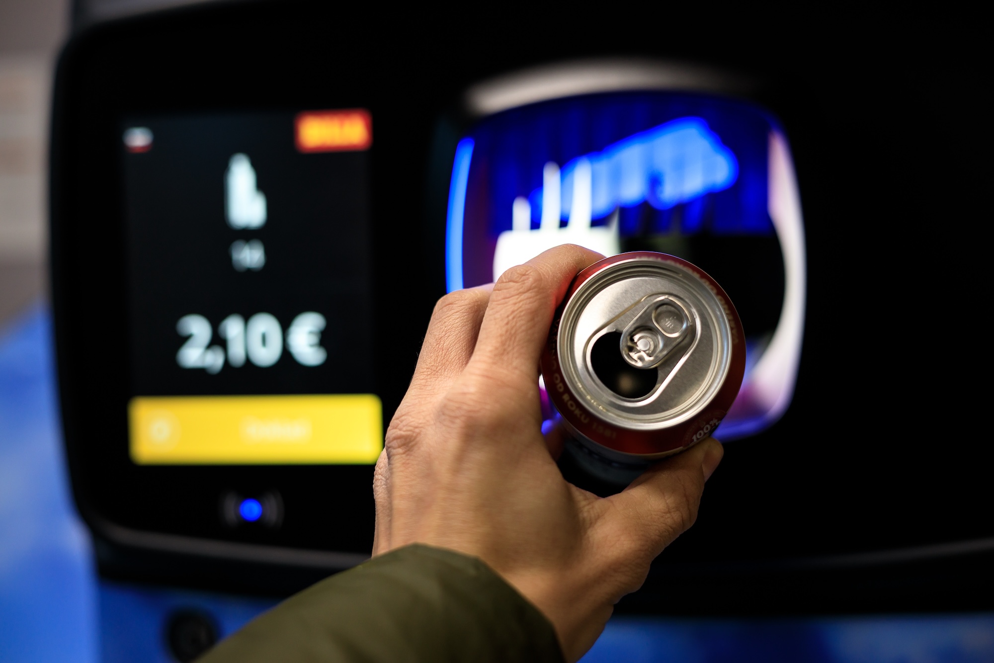recycling a can for cash in a supermarket by throwing it into a recycling machine